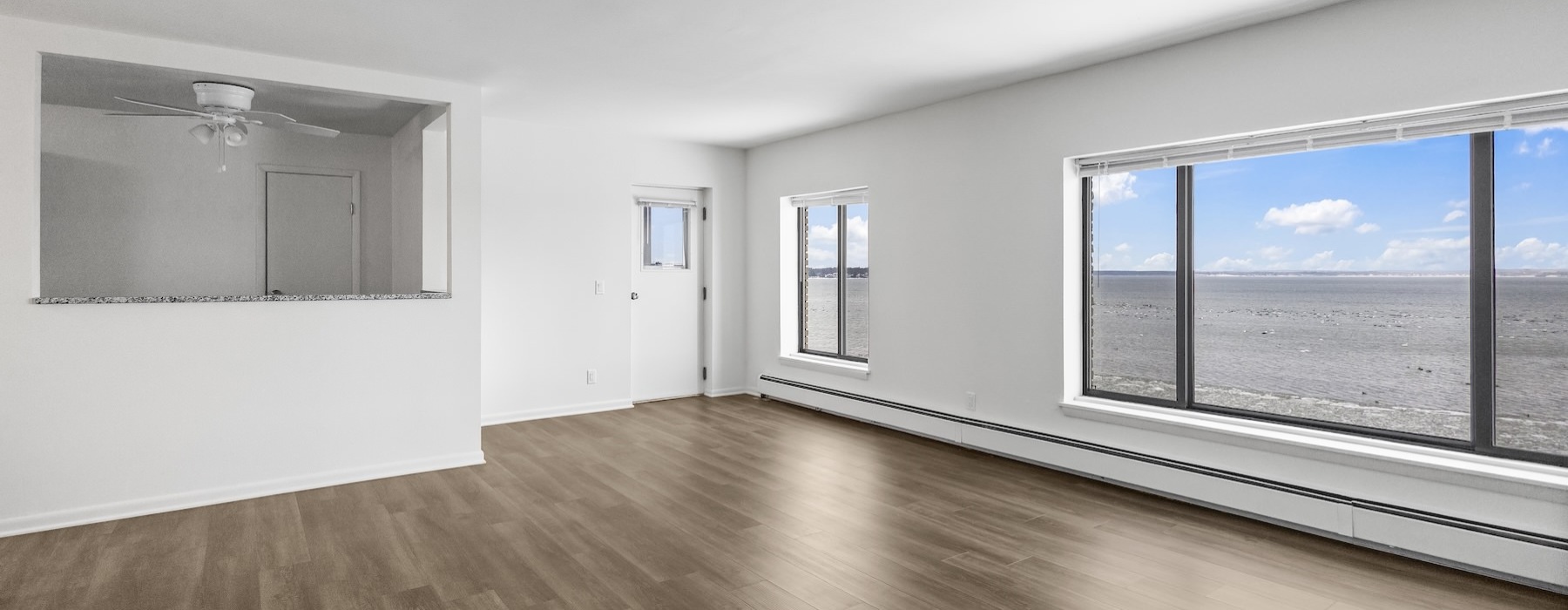 a room with a large window and wood floors